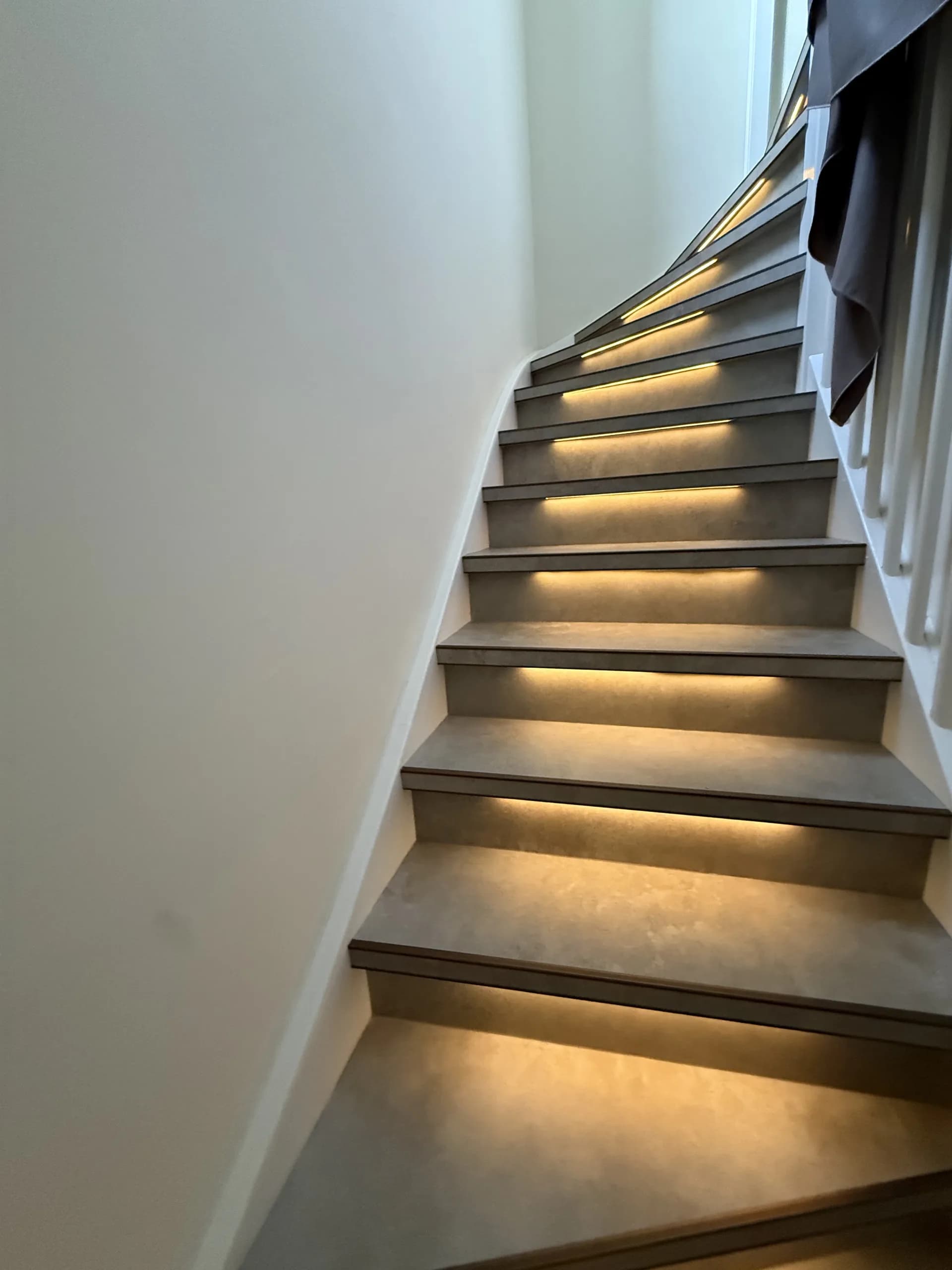 Trap met grijze tredebekleding, donkere randprofielen en verlichting, aanzicht 2