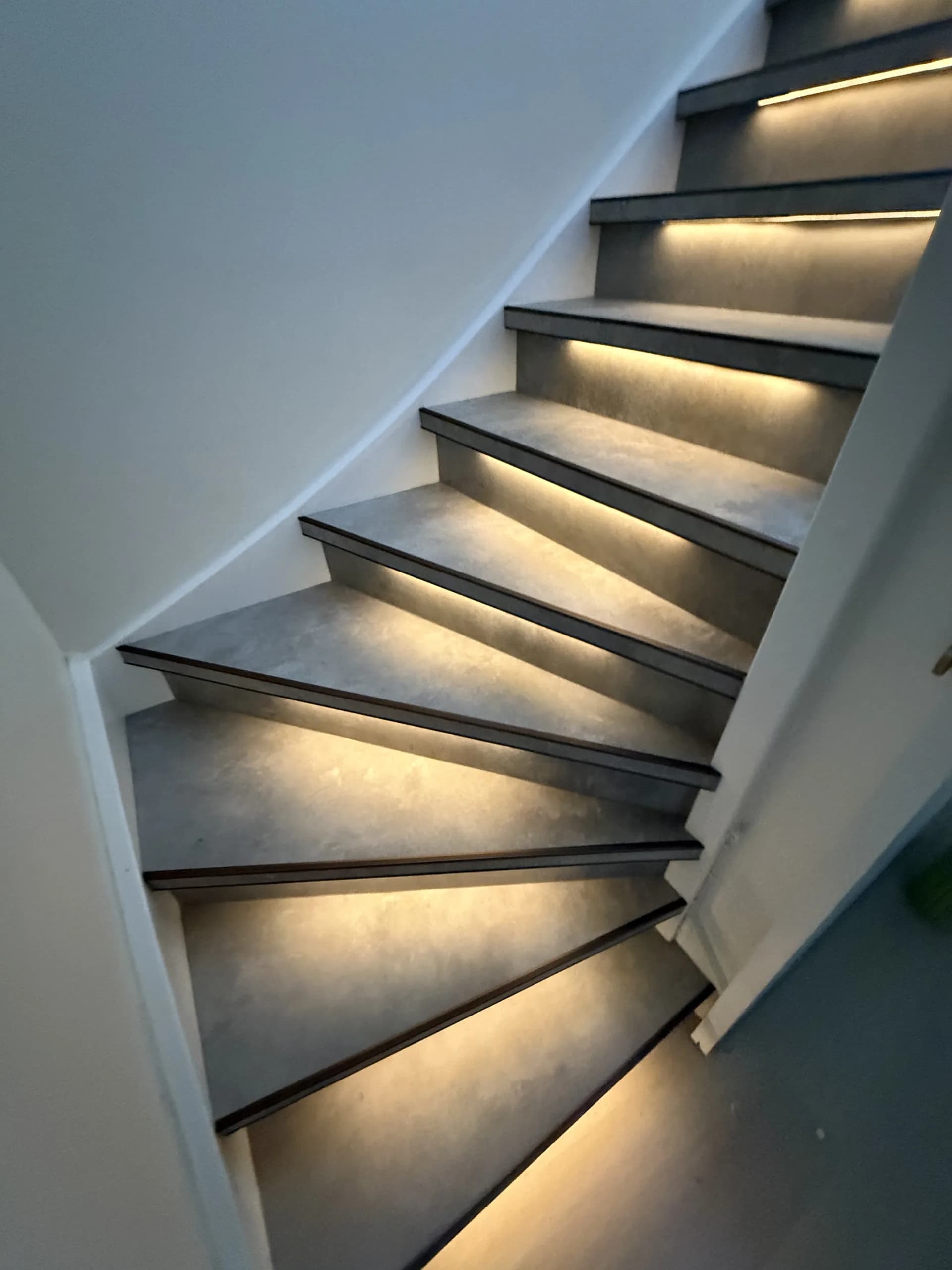 Trap met grijze tredebekleding, donkere randprofielen en verlichting, aanzicht 1